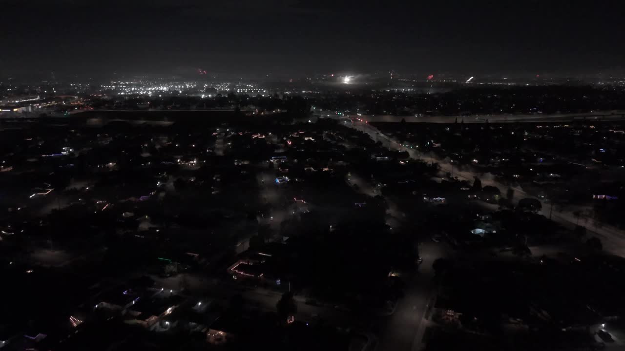 无人机拍摄的道路上的汽车行驶在夜间照明的城市景观视频素材