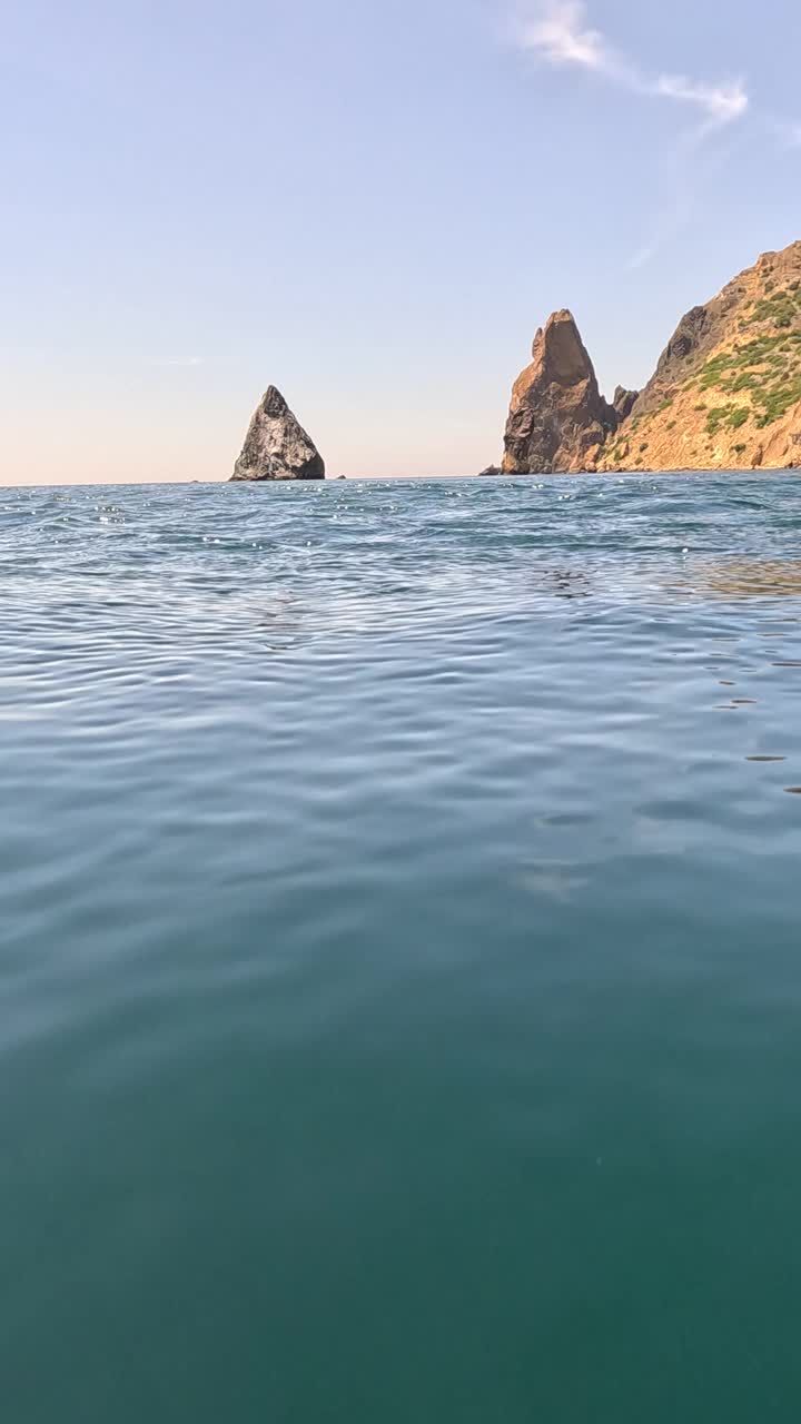 海水表面。从皮艇的低角度看，相机飞过清澈的海水。没有人。假日休闲概念。抽象航海夏季海洋自然。缓慢的运动。关闭了。垂直视频视频素材