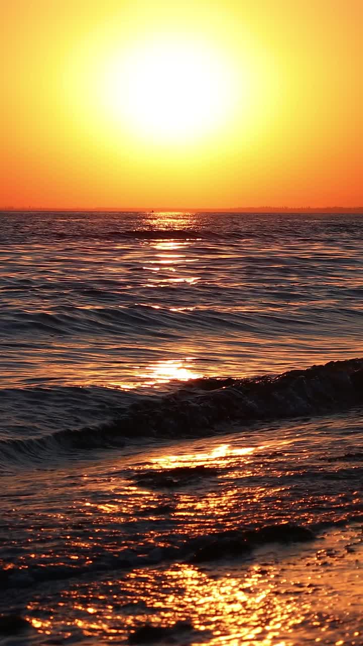 日落时的海景。波浪在落日的余晖中飞溅。视频素材