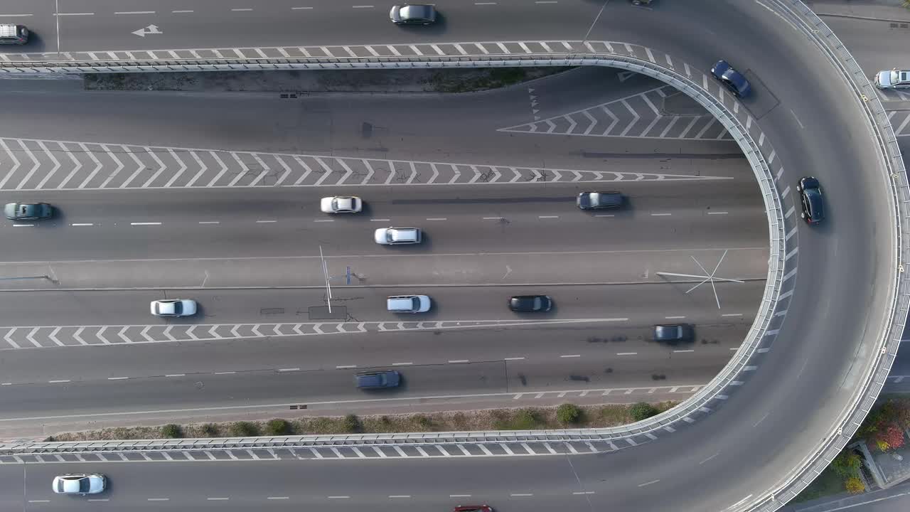 一条宽阔的柏油路，中间有白色的斑纹，高速行驶的车流密集在大城市里。无人机鸟瞰图视频下载