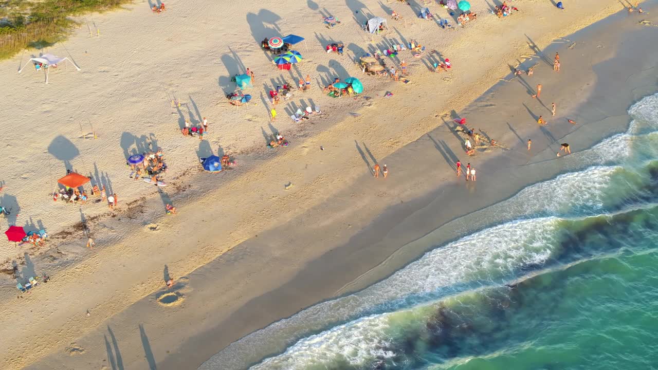 美国萨拉索塔县诺科米斯沙滩的空中傍晚海景。许多游客享受夏天的假期，在温暖的墨西哥海湾游泳，在炎热的佛罗里达阳光下晒日光浴视频素材