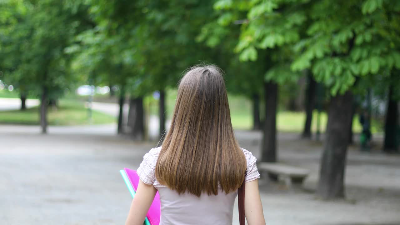 女学生在公园散步，微笑着视频素材