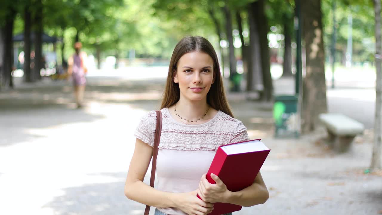 女学生在公园散步，微笑着视频素材