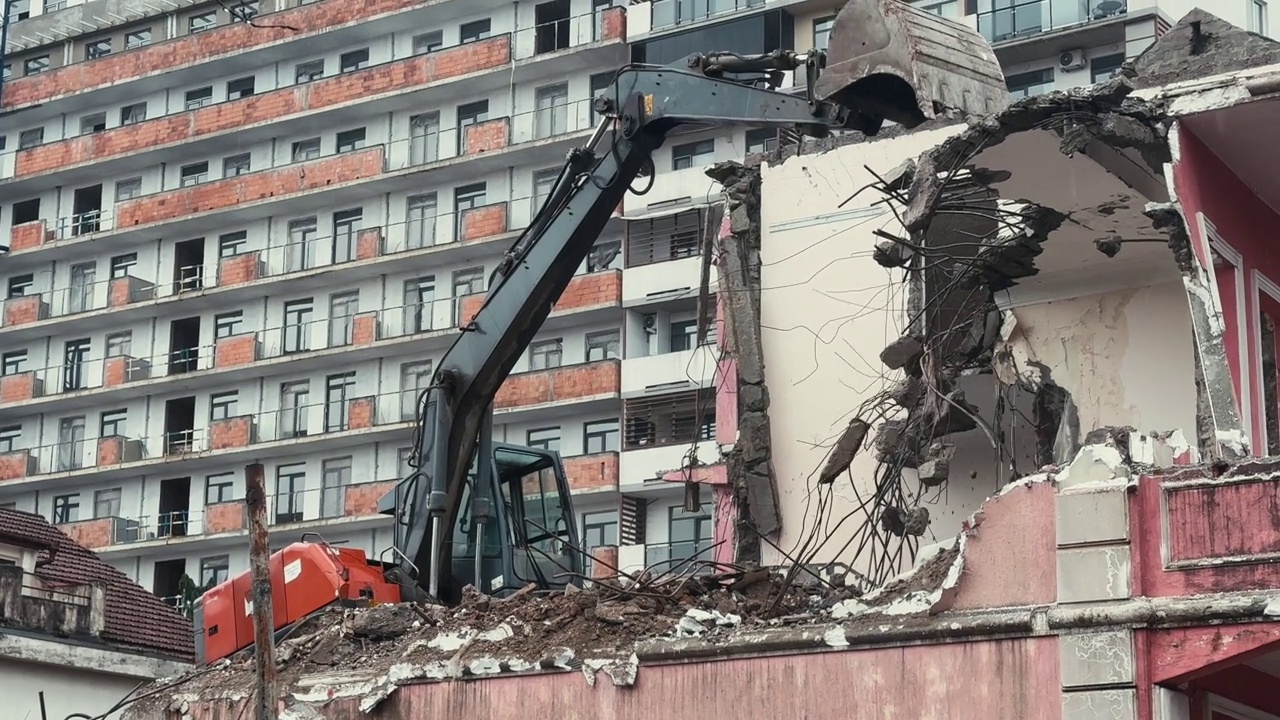 挖掘机在雨天拆除或拆除旧的废墟建筑。现代城市中旧房拆迁、新建、改造等视频素材