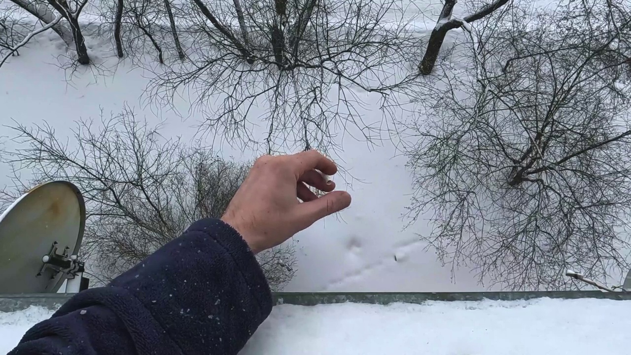 透过高层建筑的窗户吸烟，背景是大雪和冬日，第一人称视频素材