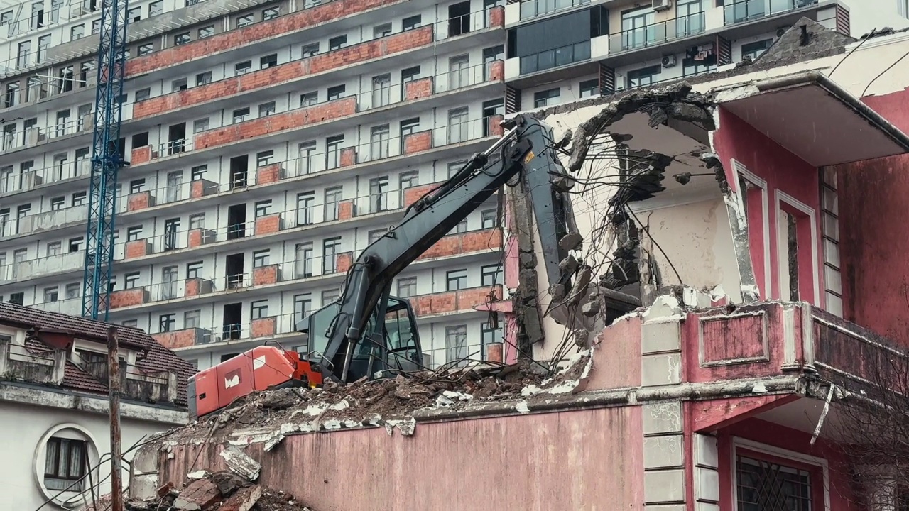 挖掘机在雨天拆除或拆除旧的废墟建筑。现代城市中旧房拆迁、新建、改造等视频素材