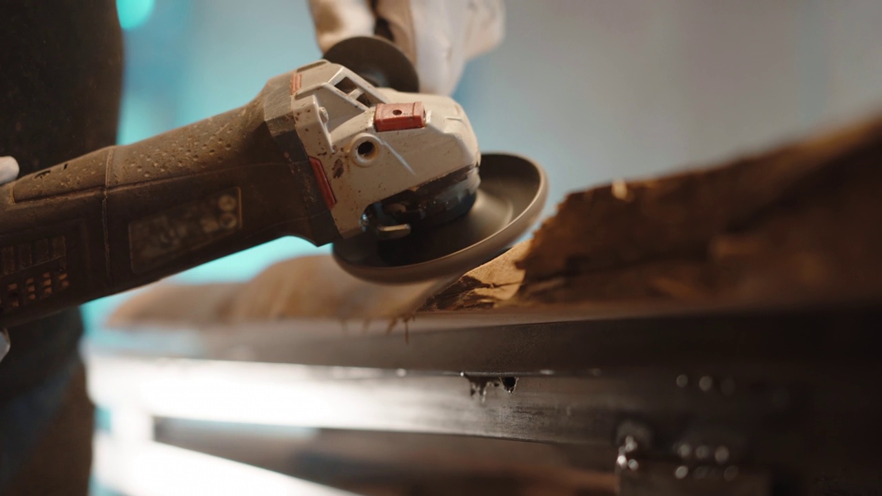 木工车间用磨床对木板角度进行低角度的打磨，木工师傅在均匀改善木板质感的表面打磨，打磨过程中木屑在空气中飞扬。准备木材的最后加工，细木工视频素材