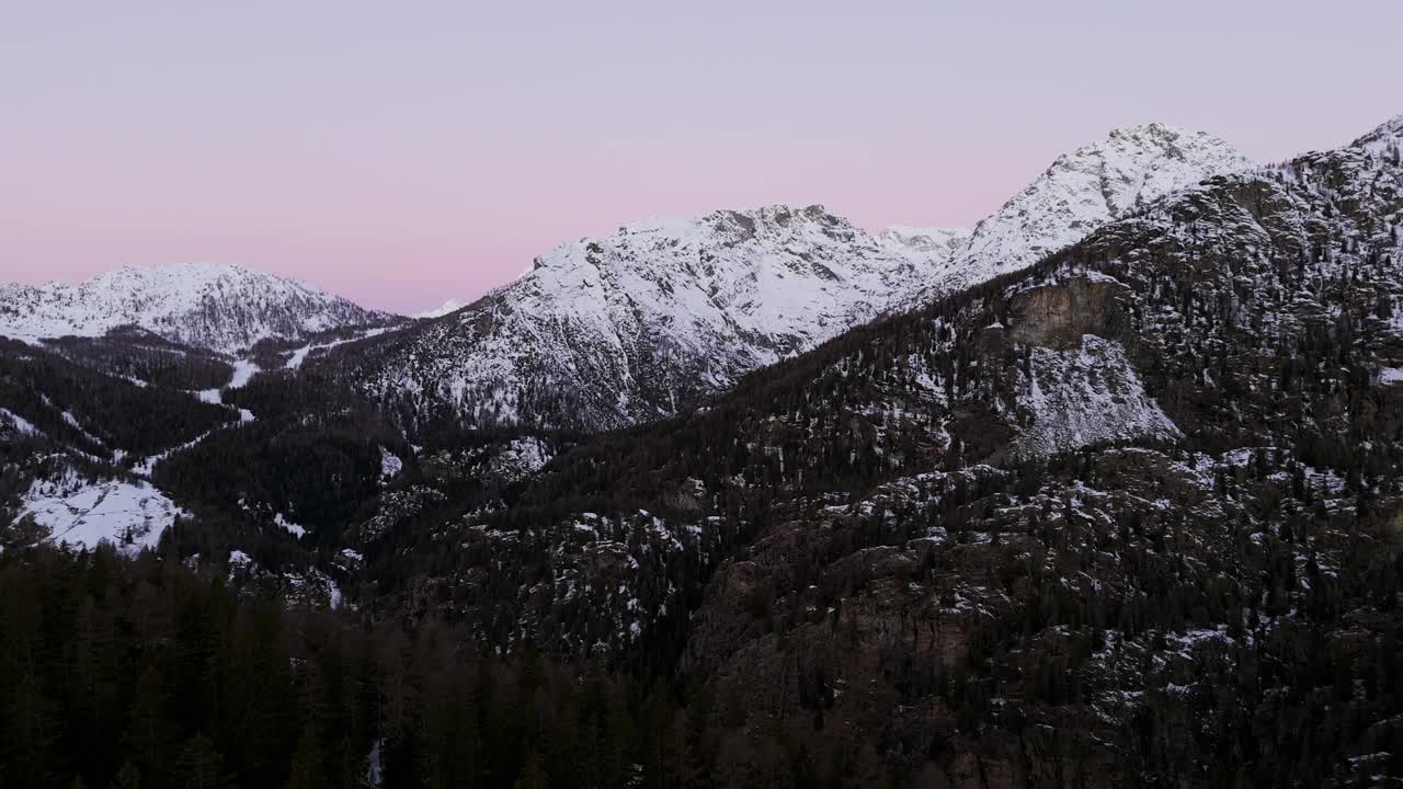 粉红色的天空越过意大利阿尔卑斯山的雪山。无人机航拍图视频素材