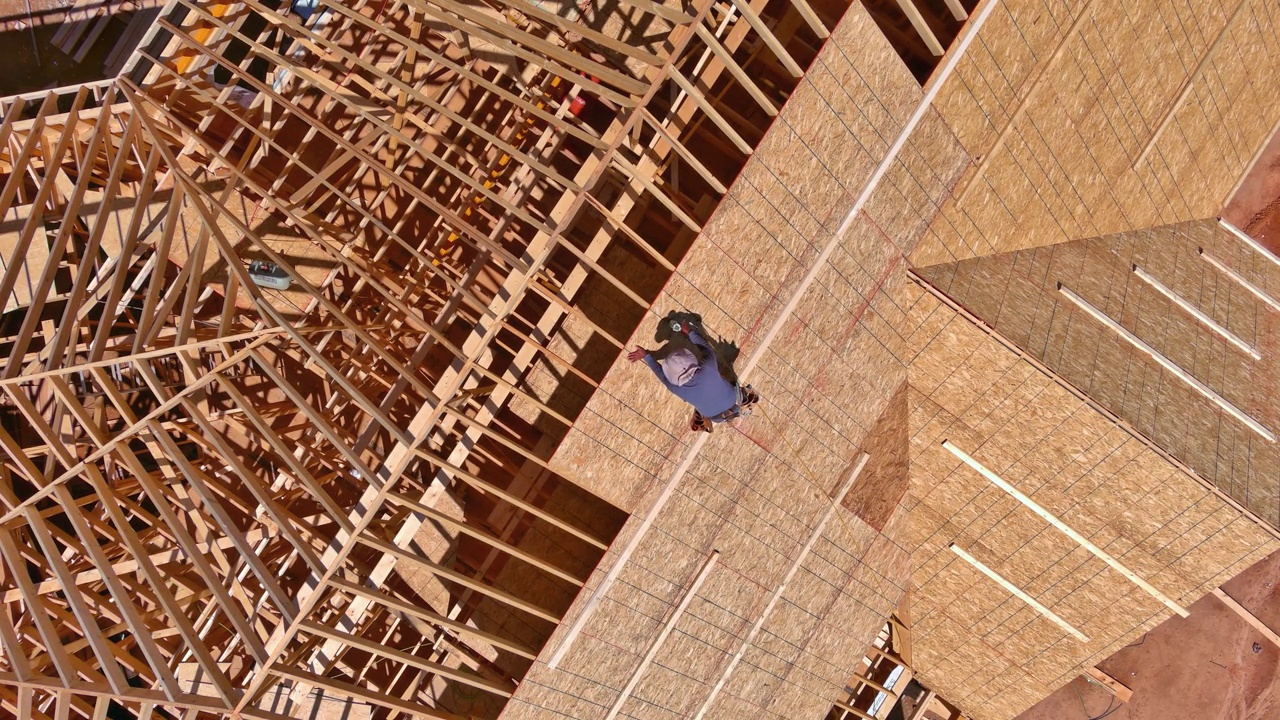 木工建筑工人在未来住宅屋顶的胶合板上钉钉子视频素材