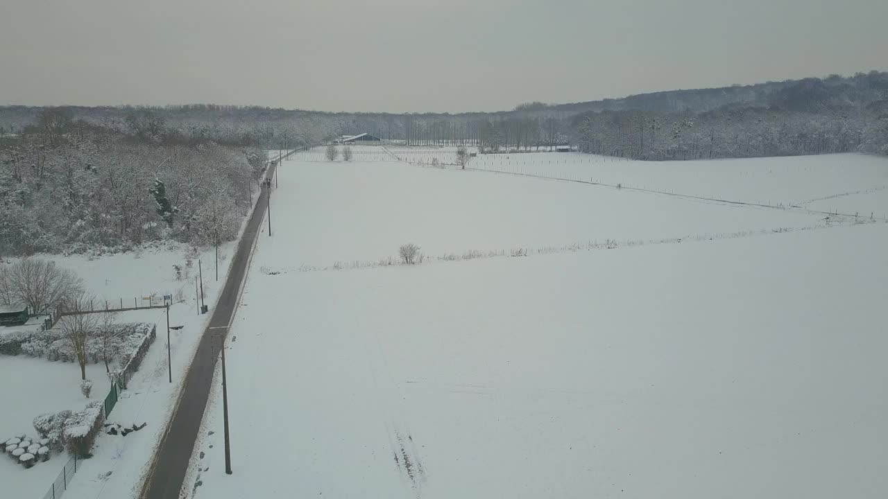 鸟瞰一条被雪覆盖的乡村道路视频下载