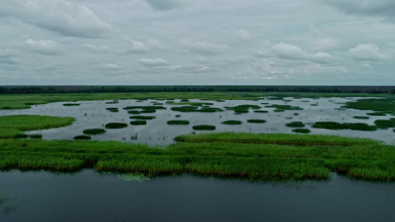 空中淹没的湖泊，绿草如茵，人们在农村骑皮艇水上运动视频素材