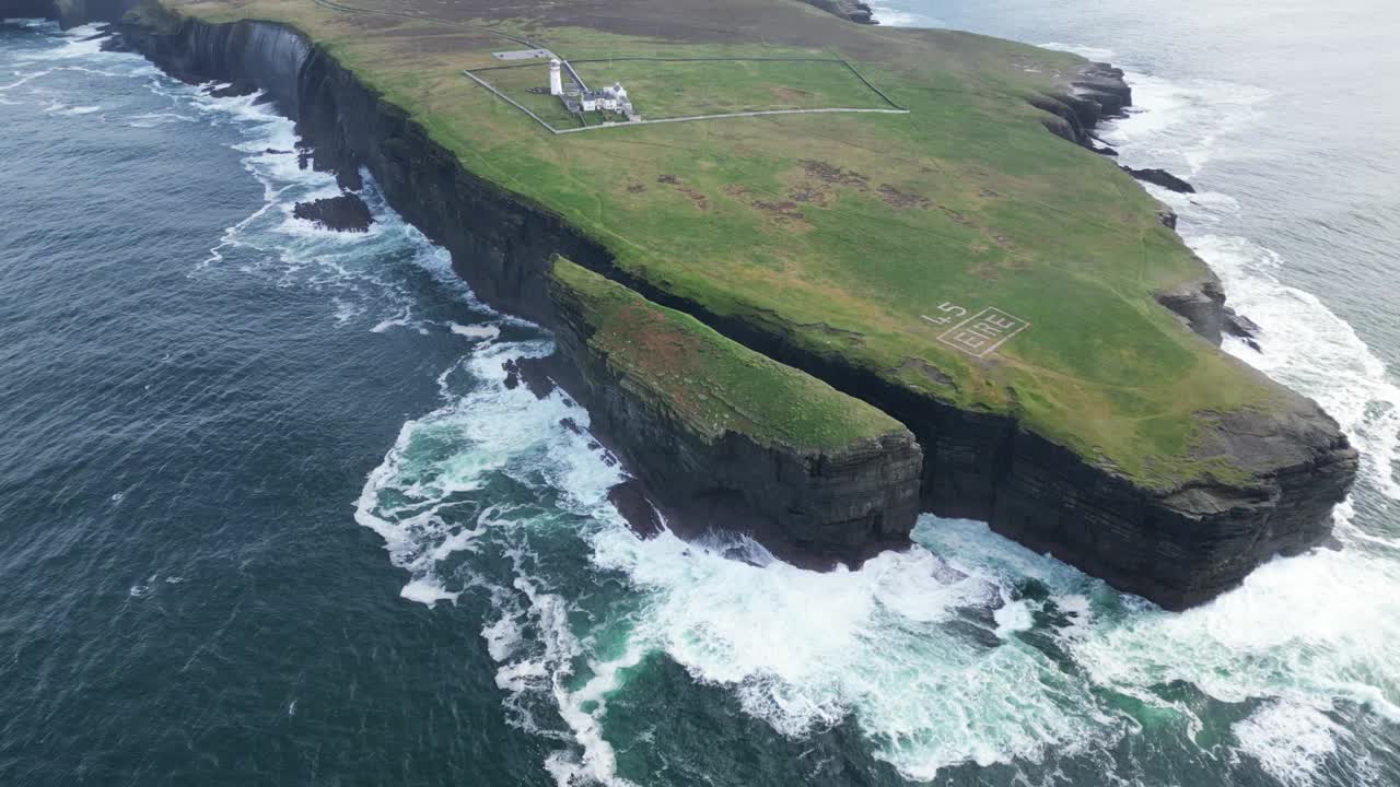 鸟瞰崎岖的海岸线，上面有“ÉIRE”的标志，海浪撞击悬崖，历史标志视频素材