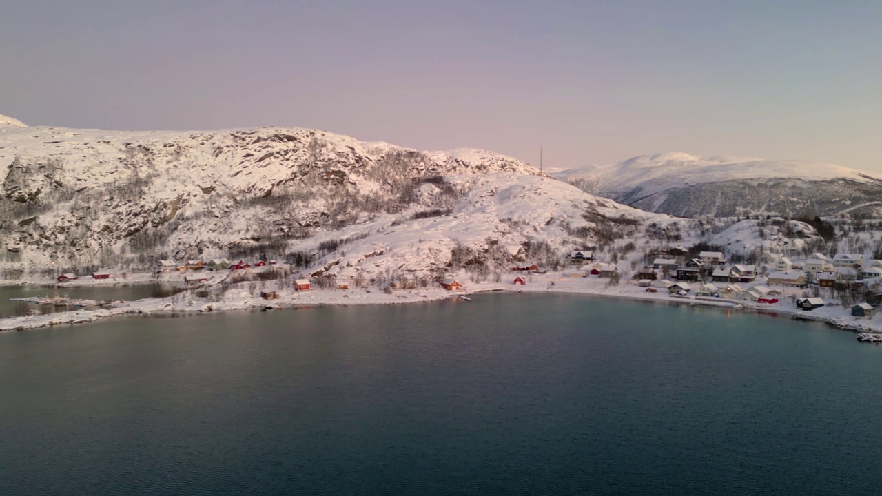 鸟瞰图，ersjordvegen村在冬天被雪覆盖，水面平静视频素材