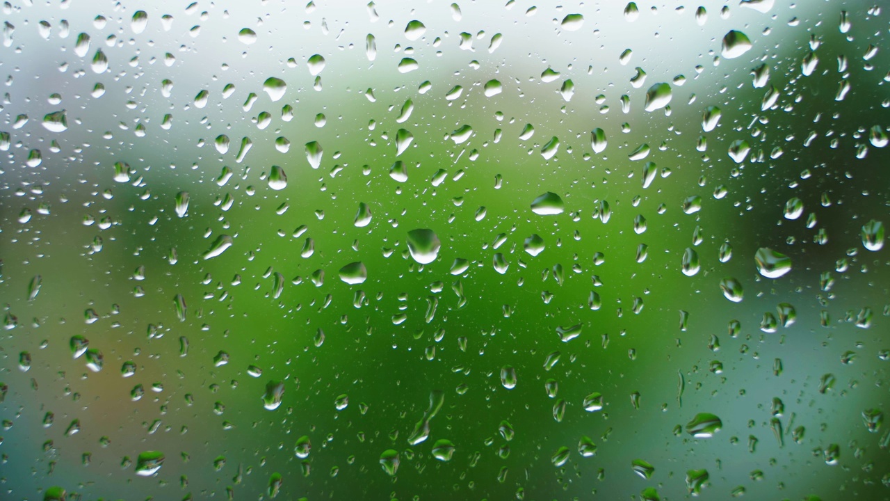 雨滴顺着玻璃特写镜头流下。秋雨天气时的窗户。背景，雨季视频素材