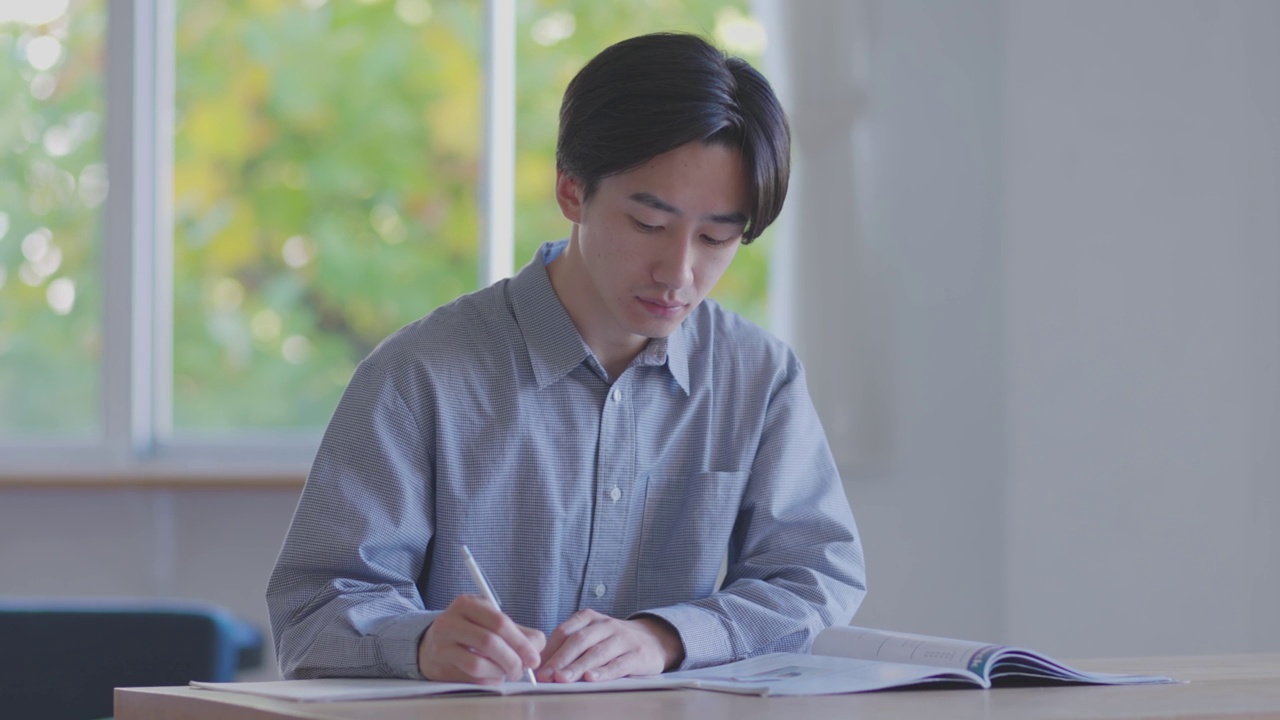 在客厅学习的日本男大学生视频素材