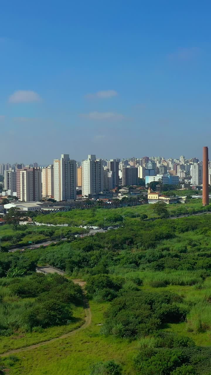 在晴朗的蓝天下，无人机拍摄的现代城市景观视频素材