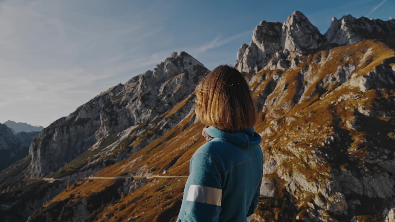 令人敬畏的高度:女人在山顶上沐浴阳光视频素材