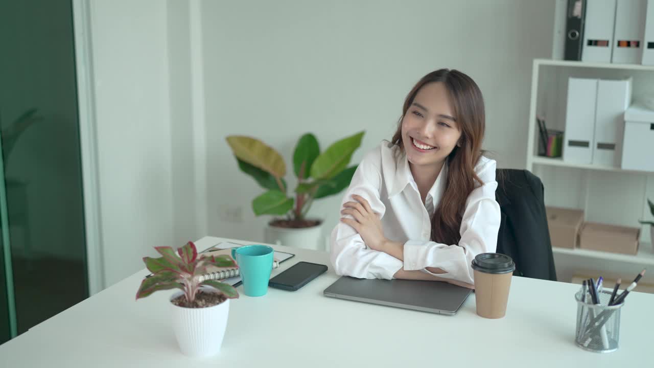 年轻的亚洲女子下班后拿着手机放松。视频素材