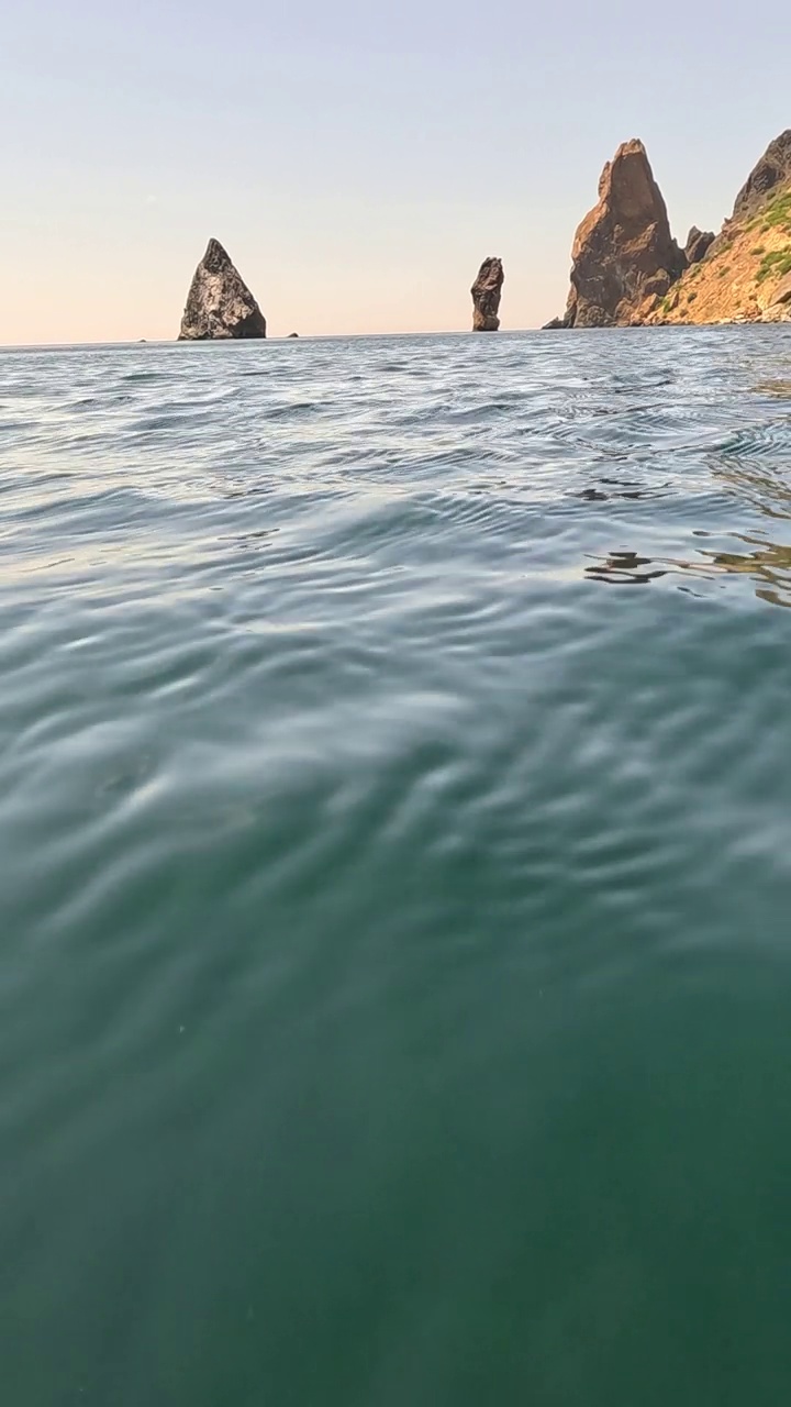 海水表面。从皮艇的低角度看，相机飞过清澈的海水。没有人。假日休闲概念。抽象航海夏季海洋自然。缓慢的运动。关闭了。垂直视频视频素材