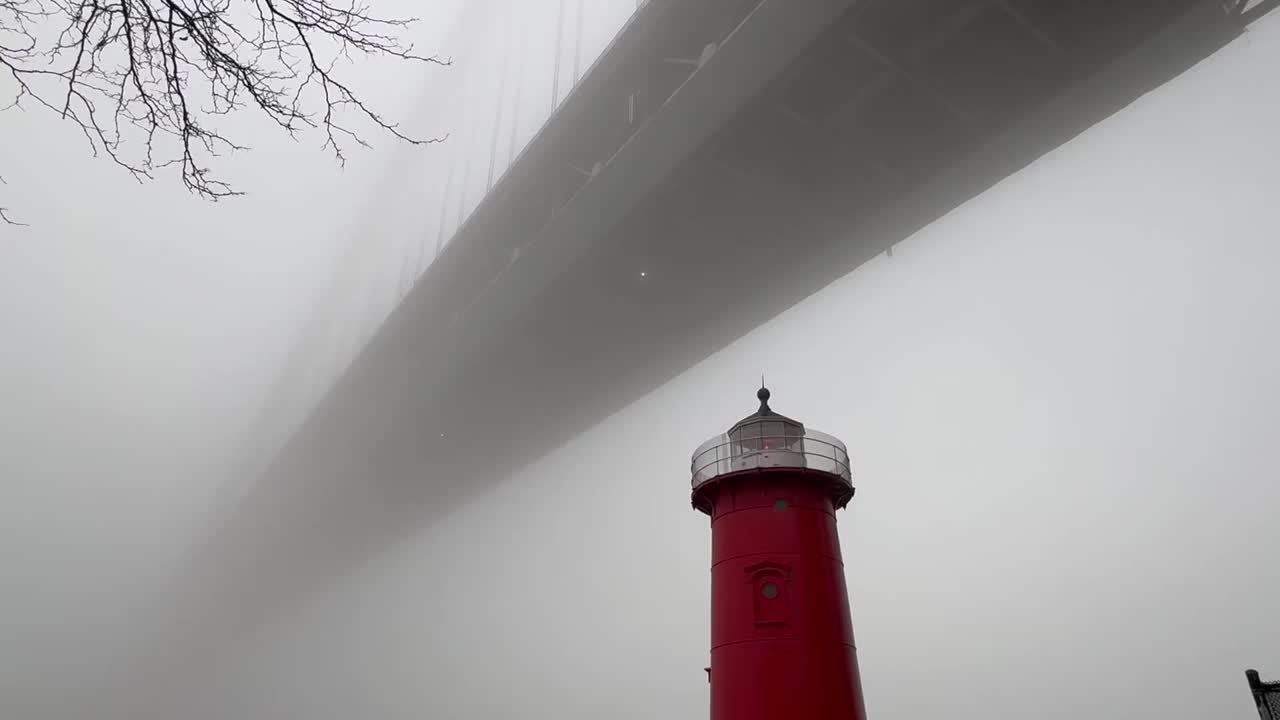 在纽约一个雾蒙蒙的冬日，乔治华盛顿大桥下的小红灯塔闪烁着红灯视频下载