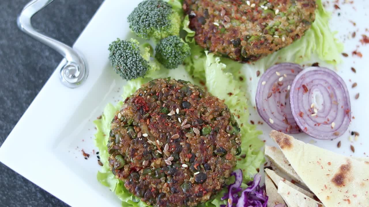 切素食汉堡肉饼(植物性肉)，用藜麦和青豆煮熟，配上新鲜蔬菜视频下载