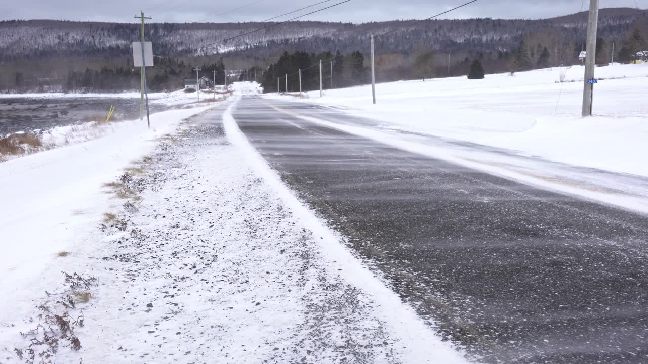 暴风雪中的乡村道路。危险的驾驶条件。视频素材