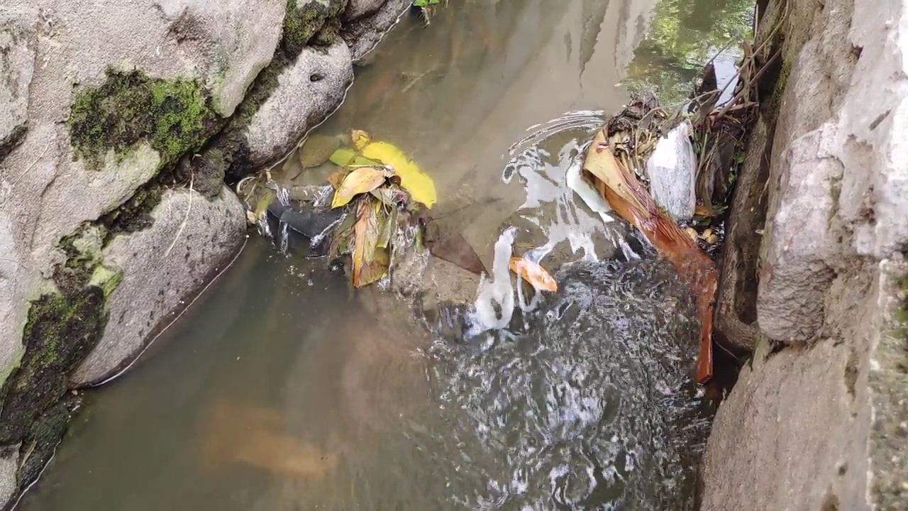 污水流进装满垃圾的沟渠，4K分辨率视频下载