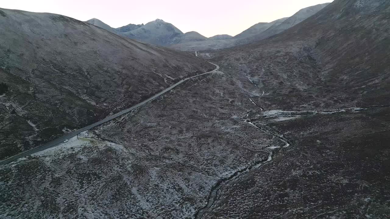 黄昏时蜿蜒的道路穿过白雪覆盖的天空，宁静而孤立，鸟瞰视频素材