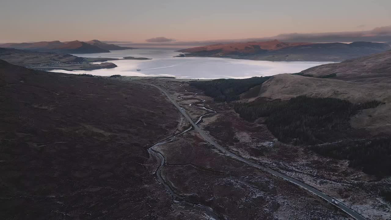 崎岖的天空岛景观黄昏与蜿蜒的道路和宁静的海湖，鸟瞰图视频素材