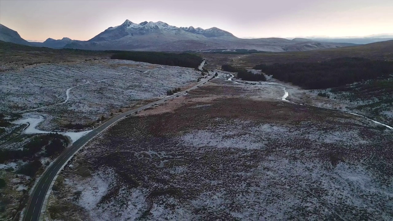 雪景在天空与蜿蜒的道路和山为背景，黄昏，鸟瞰图视频素材