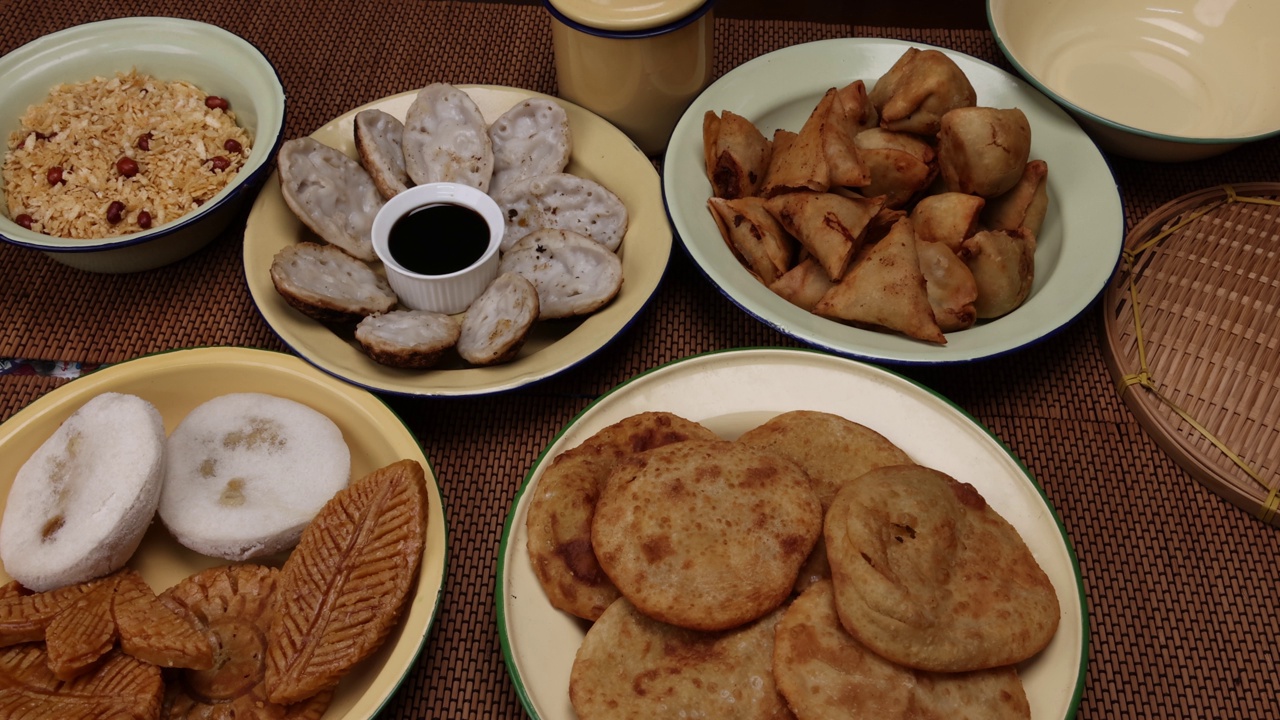 孟加拉风味小吃，各种馅煎饼chitoi bhapa nakshi pakkon pitha singara samosa dal aloo puri炸扁米饭，混合在搪瓷锡金属板上，背景质朴视频素材