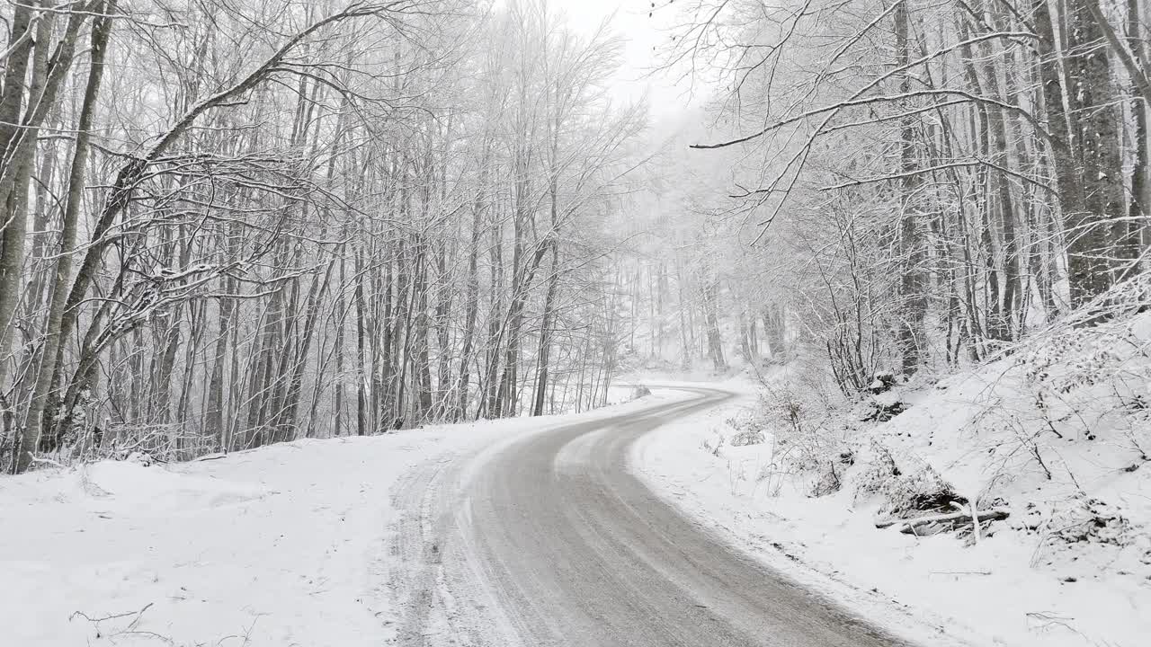 弯弯曲曲的路，树林里的雪，无人机的镜头视频下载