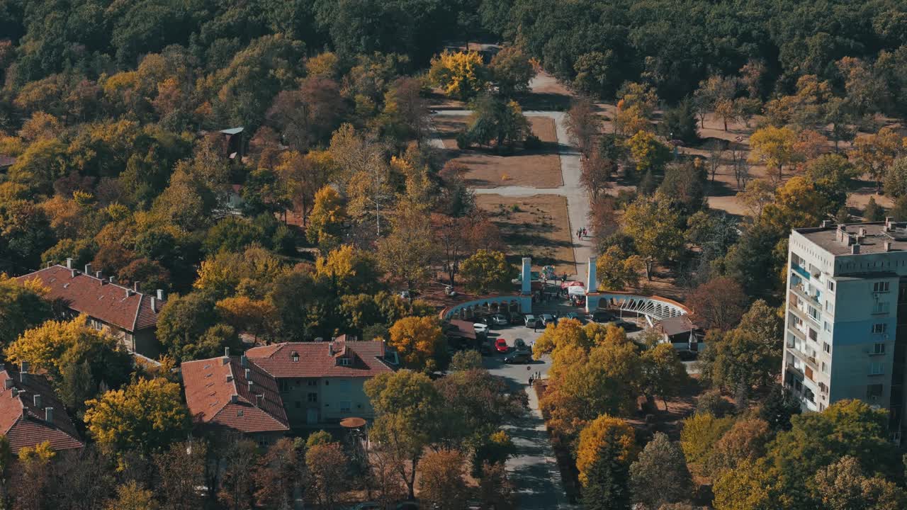 在保加利亚的季米特洛夫格勒，一架无人机在美丽的秋天树木环绕的住宅上空飞行视频素材