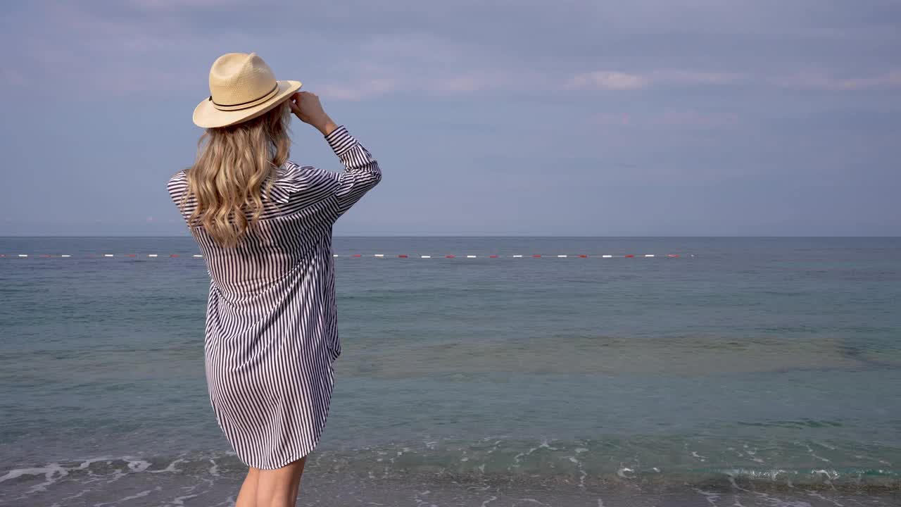 快乐的年轻女子正在海滩上散步视频素材