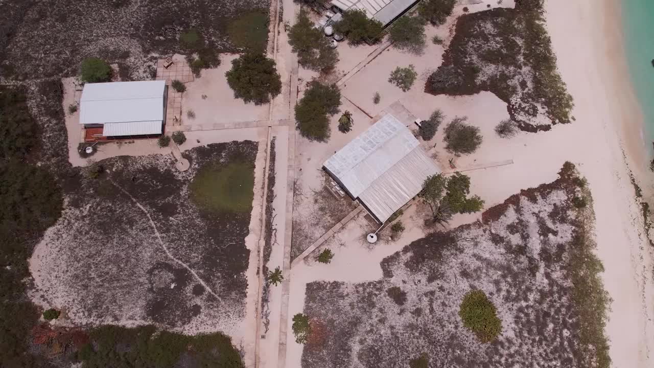 鸟瞰图，洛斯罗克群岛上有清澈碧绿的海水，白色的沙滩和散落的建筑视频素材