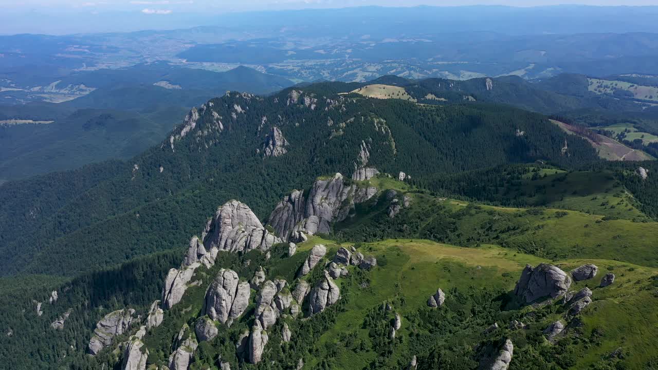 在充满活力的绿色岩石山脉和悬崖上飞行，鸟瞰图视频素材