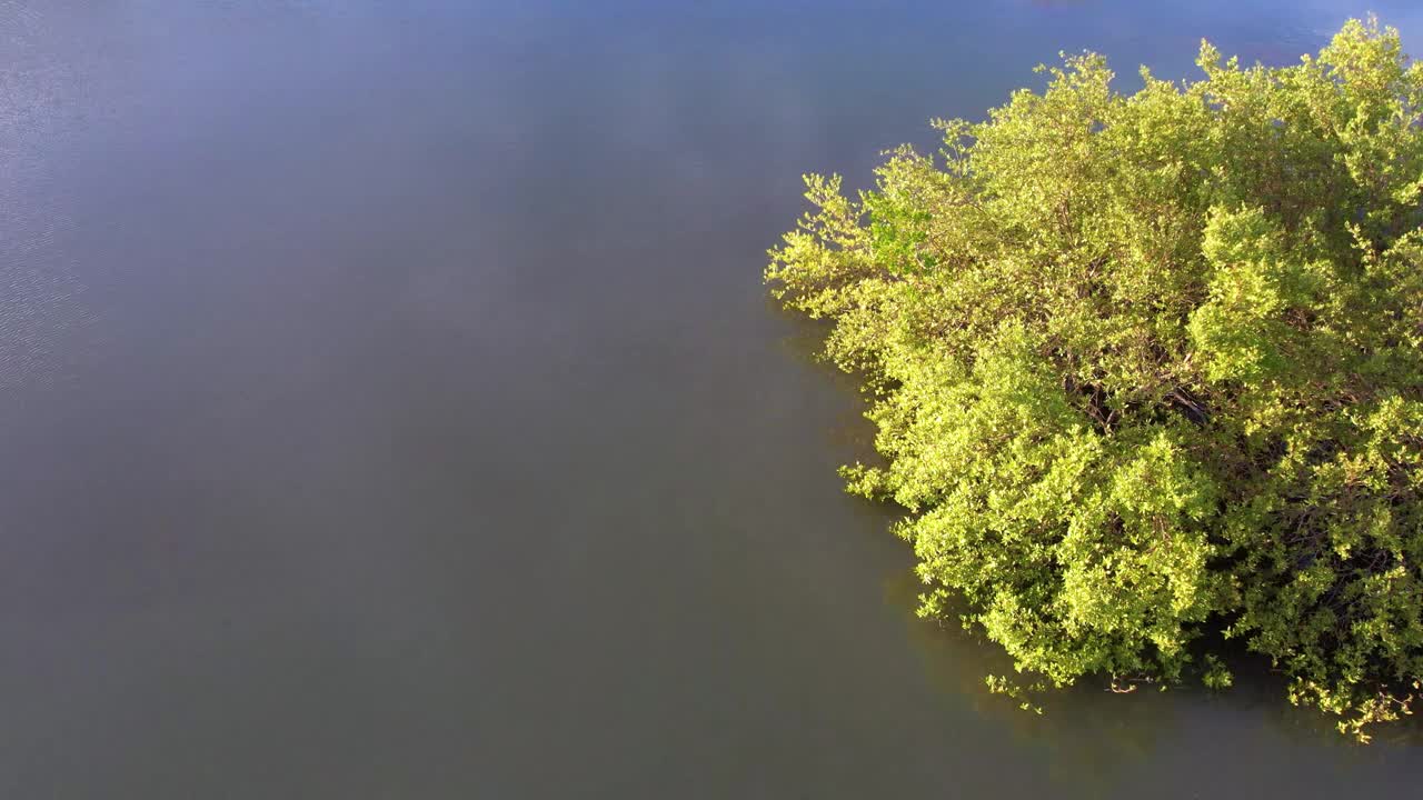 一个孤立的灯塔在崎岖的山上，旁边的海洋，蓝天，鸟瞰图视频素材