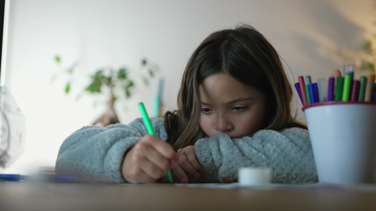 专注于小女孩用彩笔画纸，艺术儿童从事的游戏，童年的休闲活动视频素材