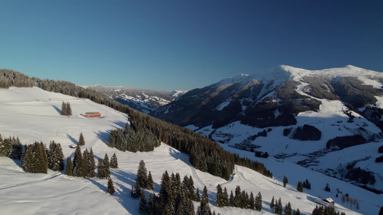 冬季雪山上的滑雪小屋和酒店建筑。Saalbach-Hinterglemm,奥地利。空中拍摄视频素材