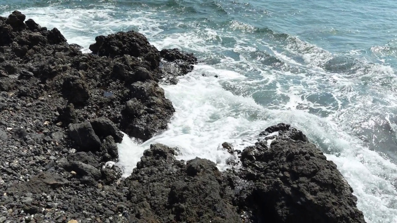 Volcanic Rocks and Foamy Waves on Tenerife's Rugged Coastline视频素材