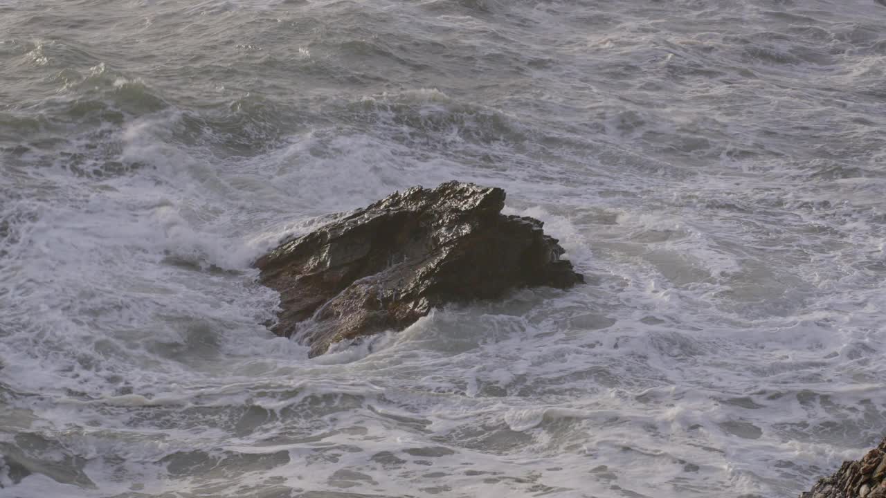 海浪冲击着海洋中一块孤独的岩石，充满活力和强大的海洋，鸟瞰图视频素材