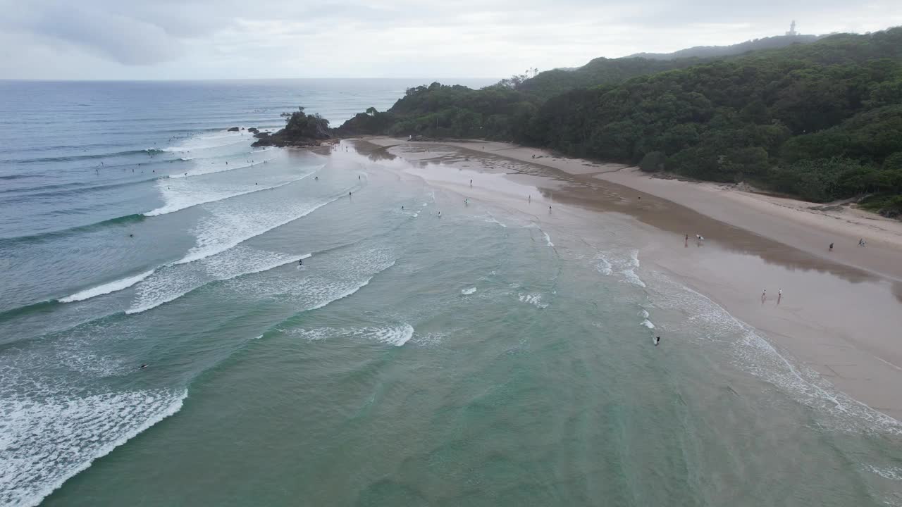 海浪飞溅的沙滩海岸的通行证海滩在拜伦湾，澳大利亚-空中无人机拍摄视频素材