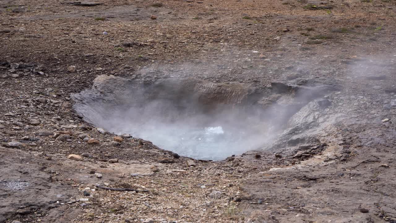 冒热气的地热喷口在冰岛的岩石地形与可见的水喷发视频素材