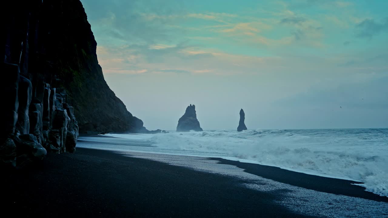 冰岛维克附近的Reynisfjara海滩全景。黑沙滩。北大西洋上引人注目的火山地标。崎岖的海岸线。海浪拍打着海岸。黑色的岩石峭壁。视频素材