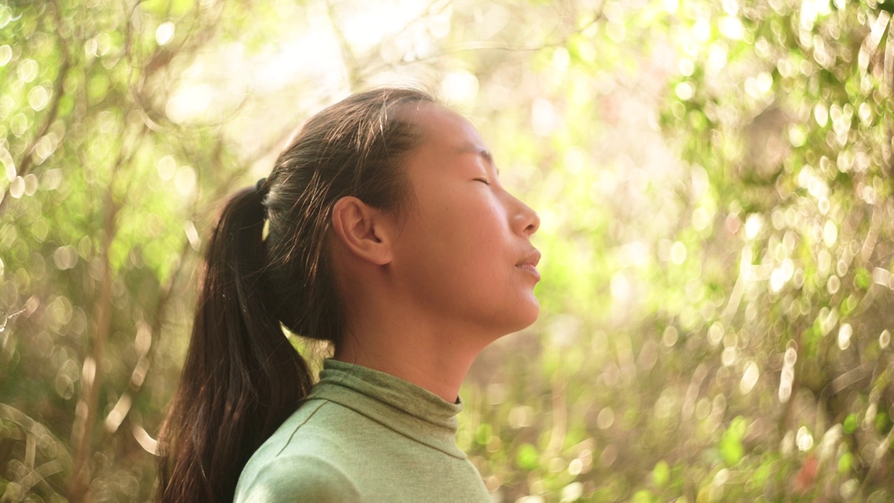 宁静的冥想:年轻女子凝视天空后对着镜头微笑视频素材