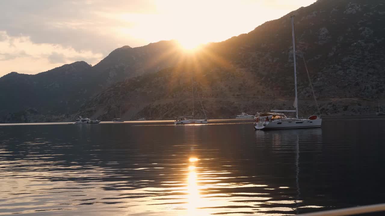 日出停泊在游艇点，太阳从山上升起，加速运动，从海上看，帆船，游艇在海湾，令人惊叹的多云的天空视频下载