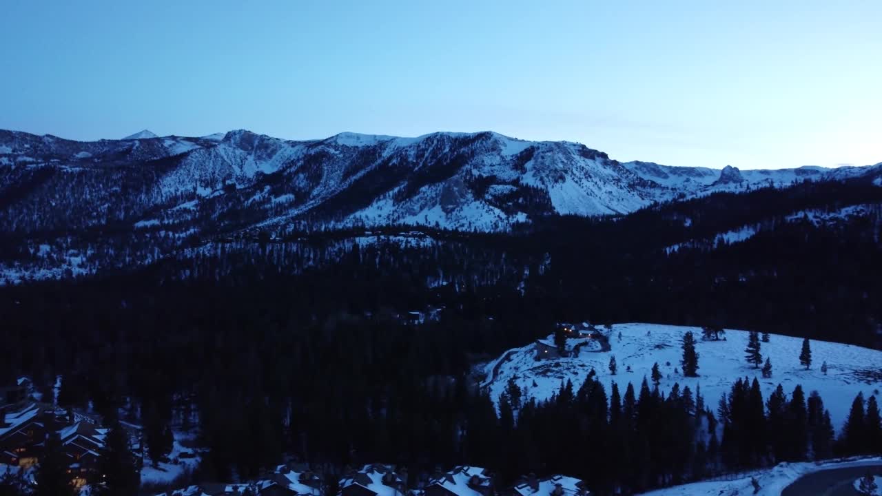 加州猛犸湖日落或黎明时，小镇或村庄和山脉的积雪覆盖的屋顶视频下载