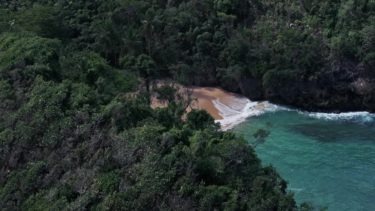 加勒比海的海浪涌向遥远的天堂海滩，周围是茂密的丛林视频素材