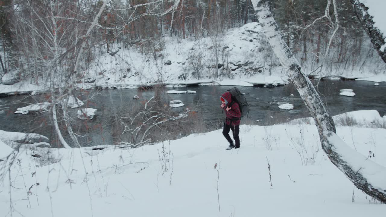 冬季徒步旅行中背着背包的游客在雪坡上行走视频素材