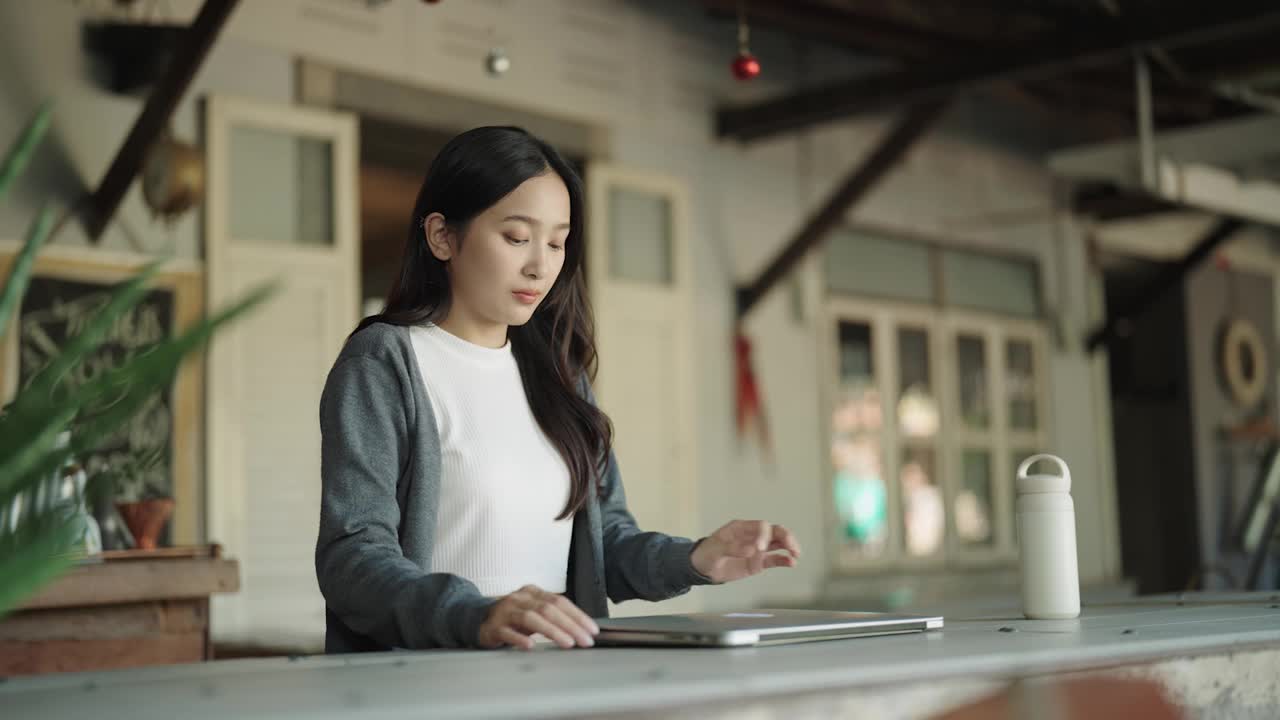 一位年轻的亚洲女性在家里使用笔记本电脑视频素材